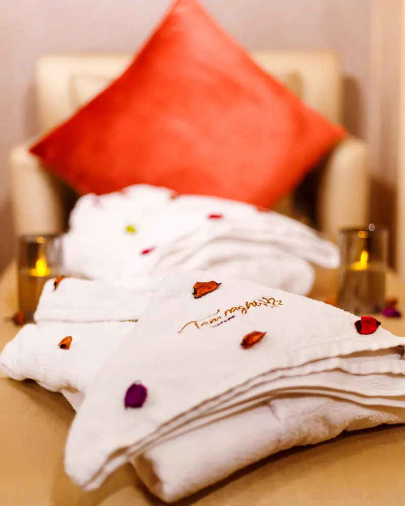 Folded white towels with rose petals - Dragonzay Photography