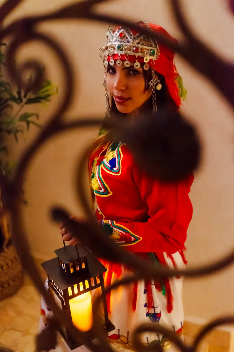 Hostess in red Berber dress in front of a mural - Dragonzay Photography
