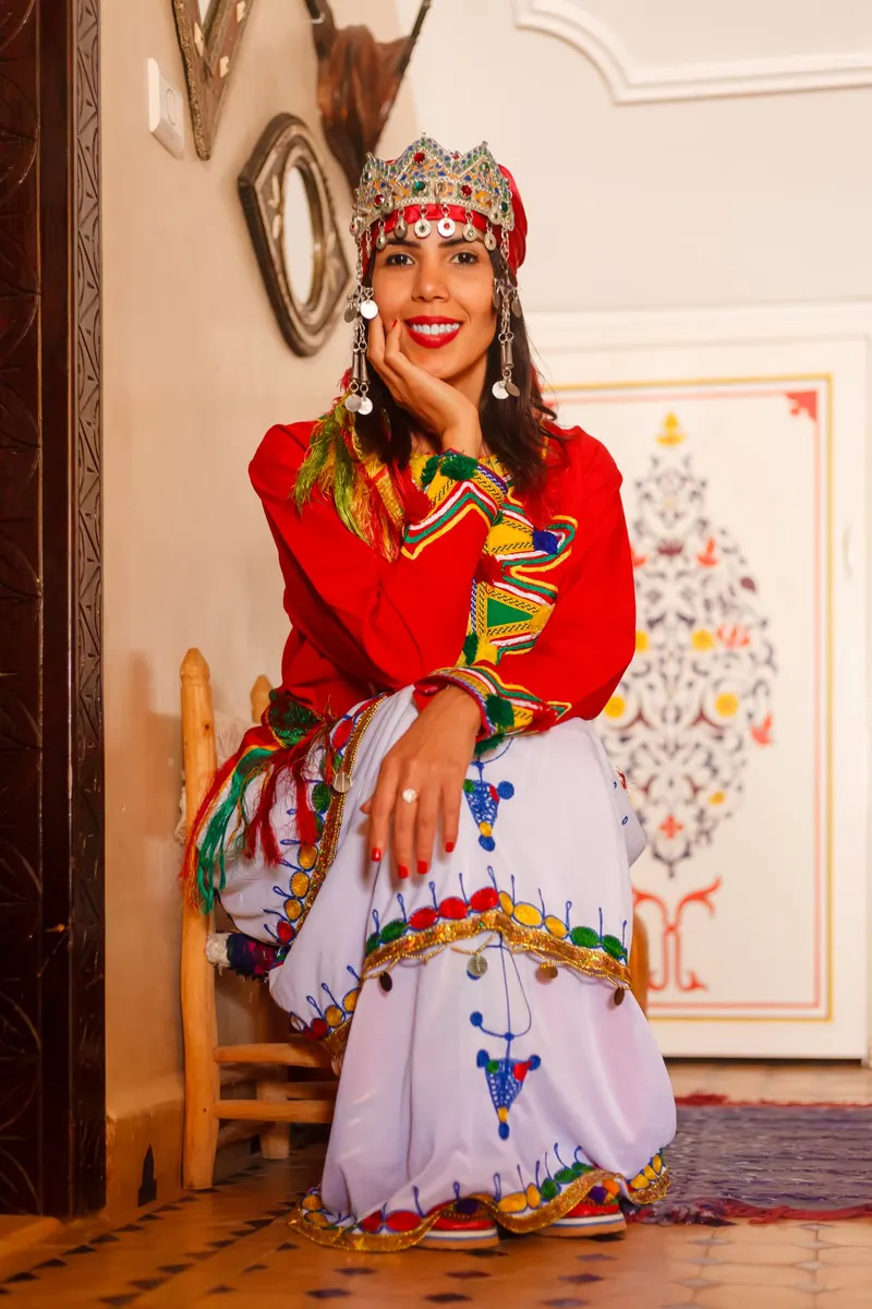Hostess in red Berber dress in front of a mural - Dragonzay Photography
