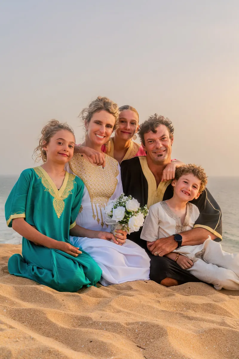 Family portrait in colourful kaftans on the beach on the wedding day - Dragonzay Photography