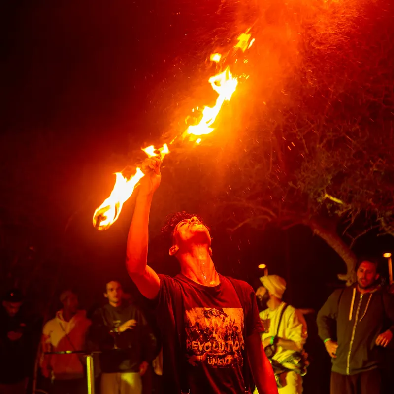 Fire performer in front of the crowd at a night festival - Dragonzay Photography