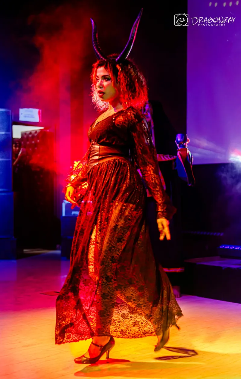 Dancer in a red dress under stage lights - Dragonzay Photography