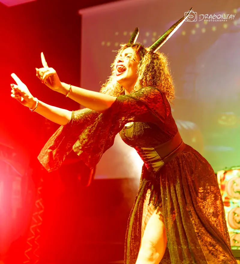 Performer in a golden costume dancing on stage - Dragonzay Photography
