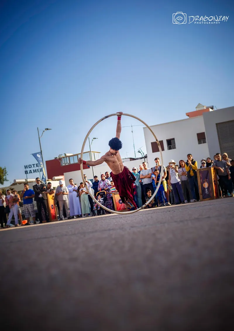Acrobat in a Cyr wheel in front of an outdoor audience - Dragonzay Photography