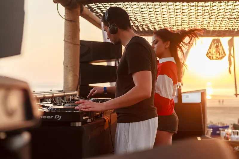 DJ mixing under a beach pergola - Dragonzay Photography