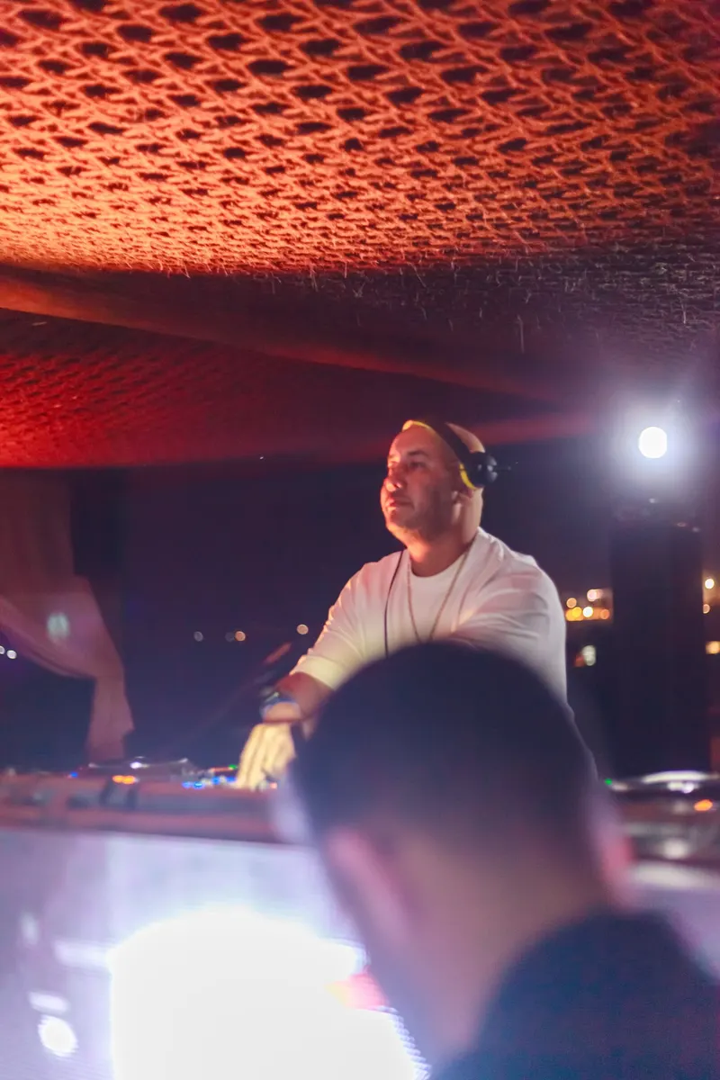DJ with headphones mixing at a night party - Dragonzay Photography