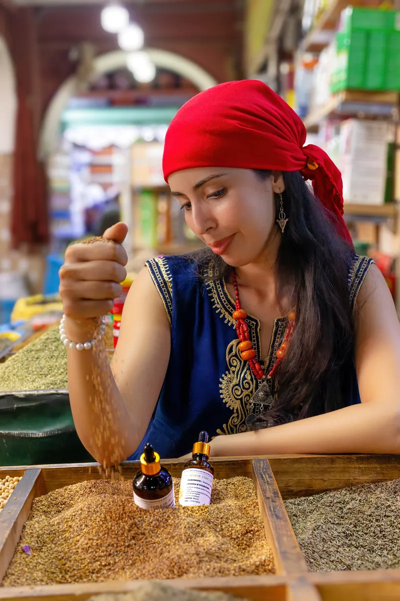 Woman in a red headscarf applying argan oil to her arm - Dragonzay Photography