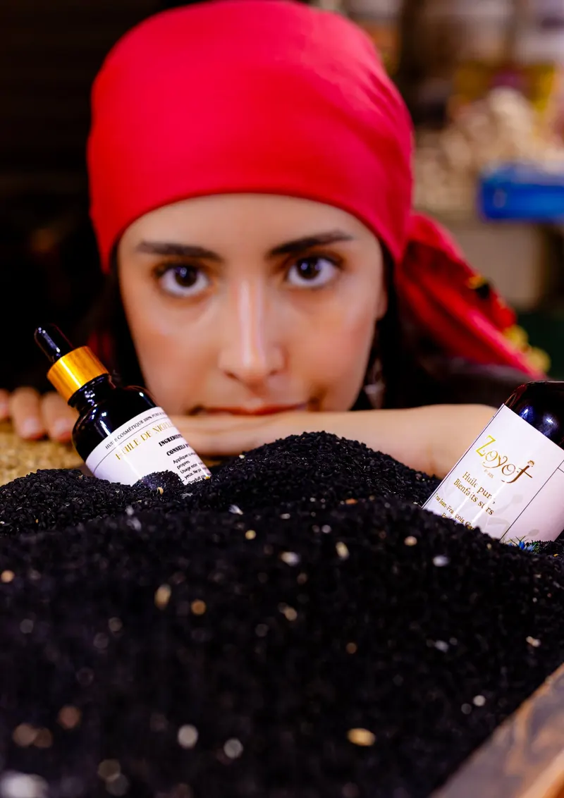 Portrait of a woman in a red headscarf with argan oil bottles - Dragonzay Photography