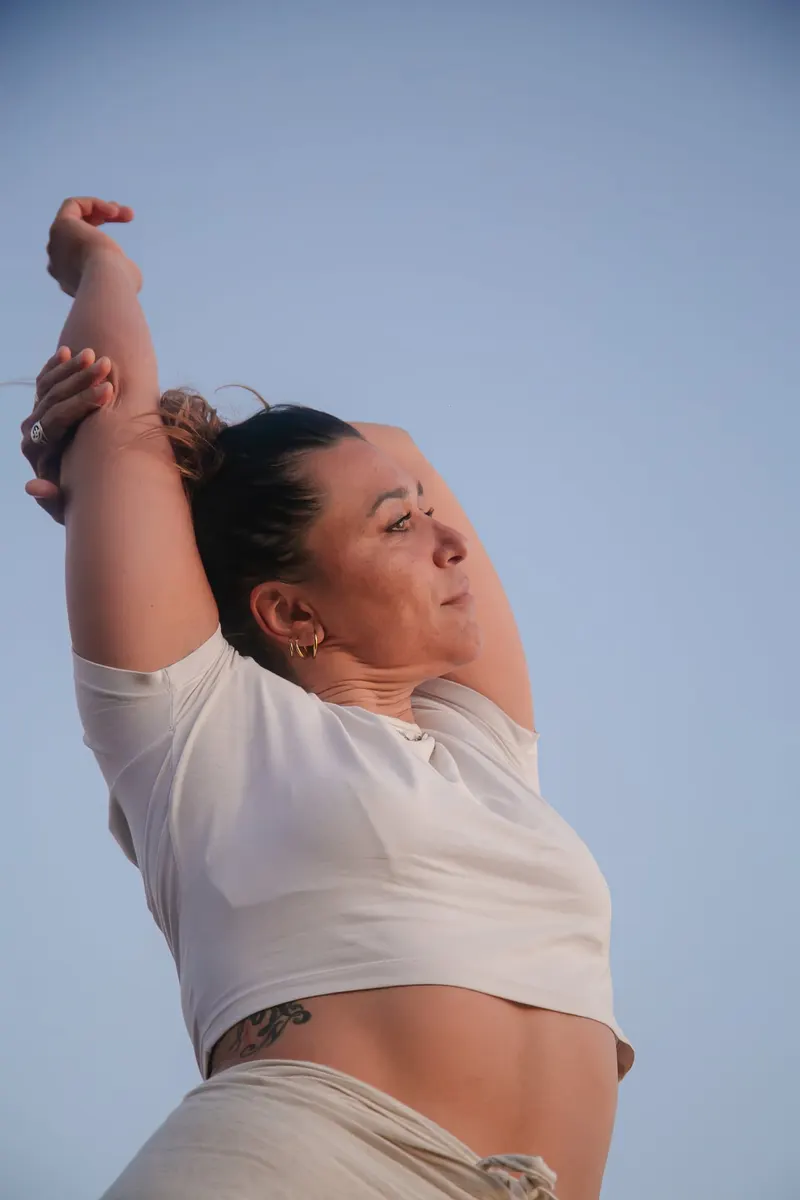 Portrait of a woman in a white tee, arm raised to the sky - Dragonzay Photography