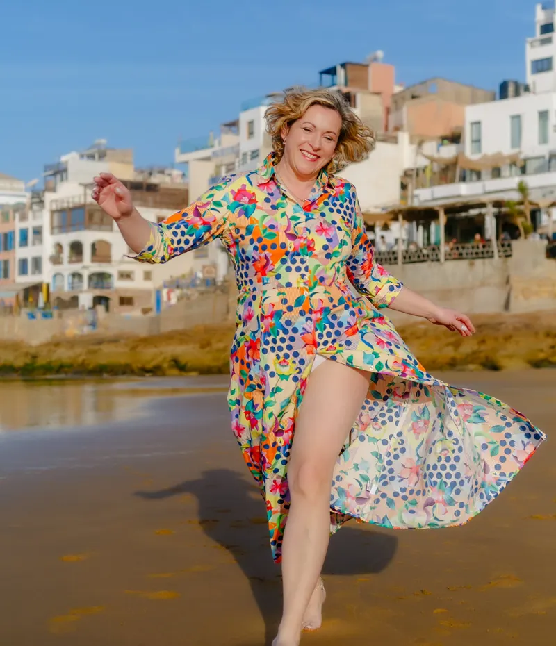 Woman in a polka dot dress walking on Taghazout beach - Dragonzay Photography