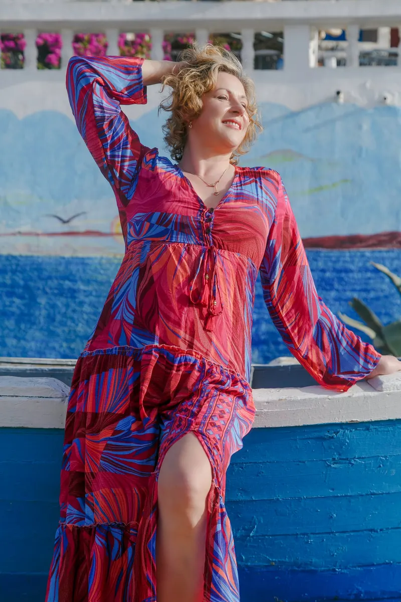 Woman in a pink and blue dress in front of a blue boat - Dragonzay Photography