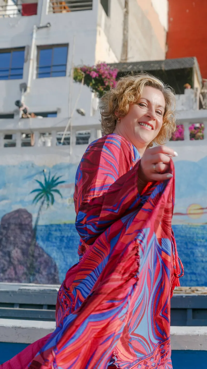 Woman in a pink and blue dress in front of a blue boat - Dragonzay Photography