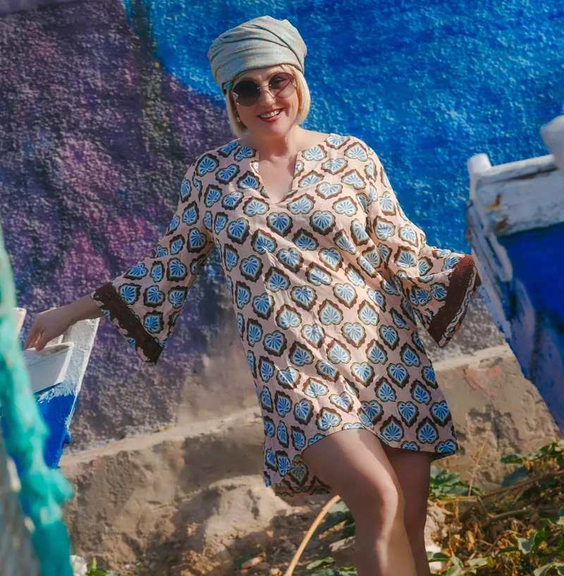 Portrait in an embroidered kaftan in front of a blue fishing boat - Dragonzay Photography