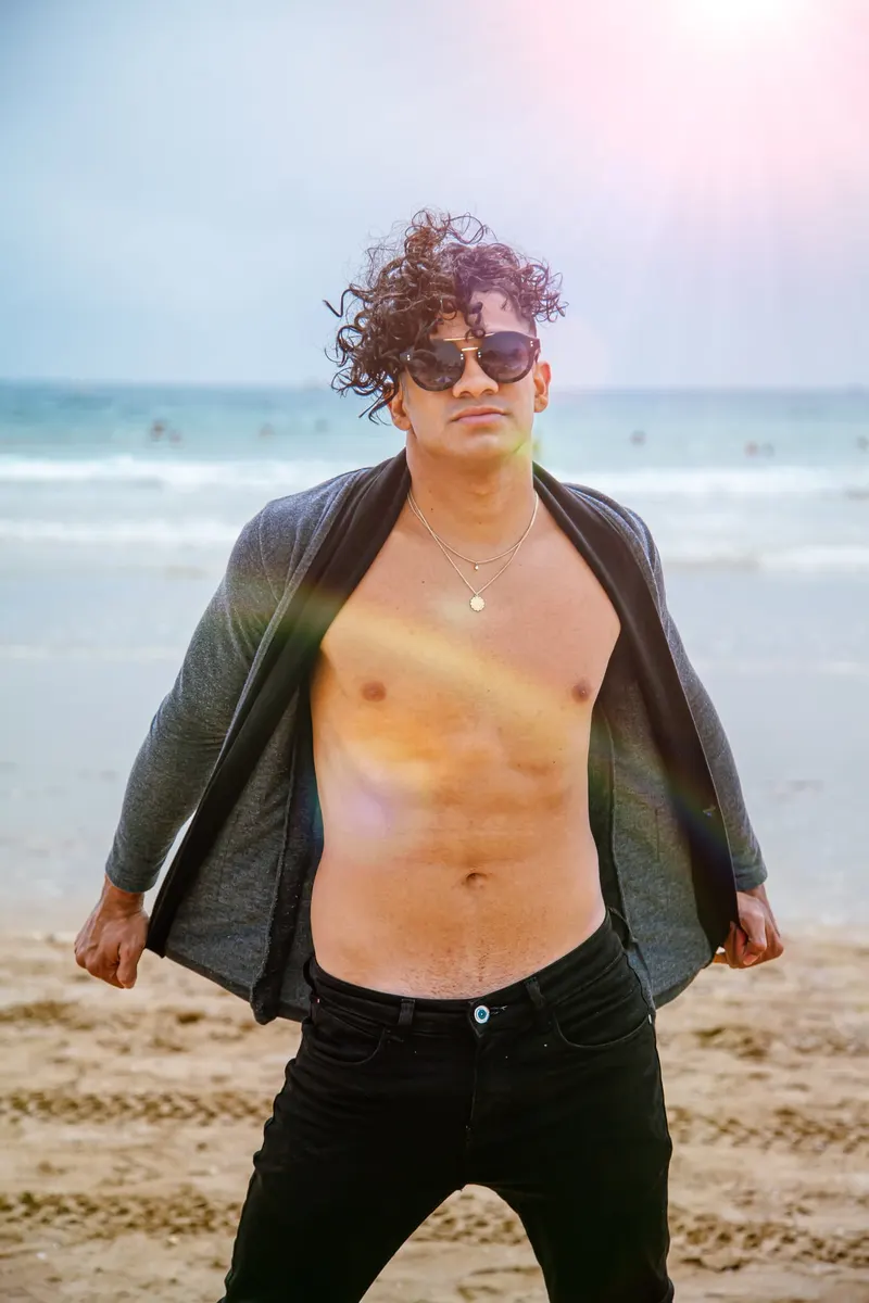 Man in an open shirt walking on the beach - Dragonzay Photography