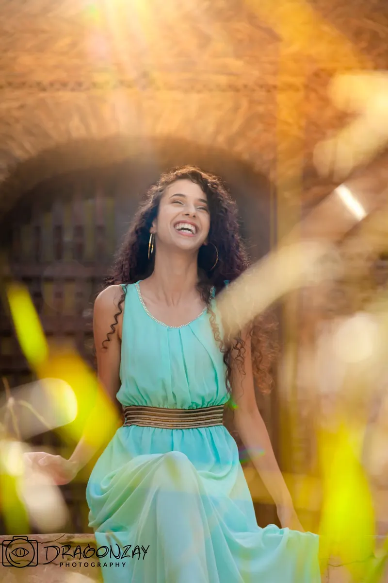 Smiling portrait in a sky-blue dress under warm lights - Dragonzay Photography