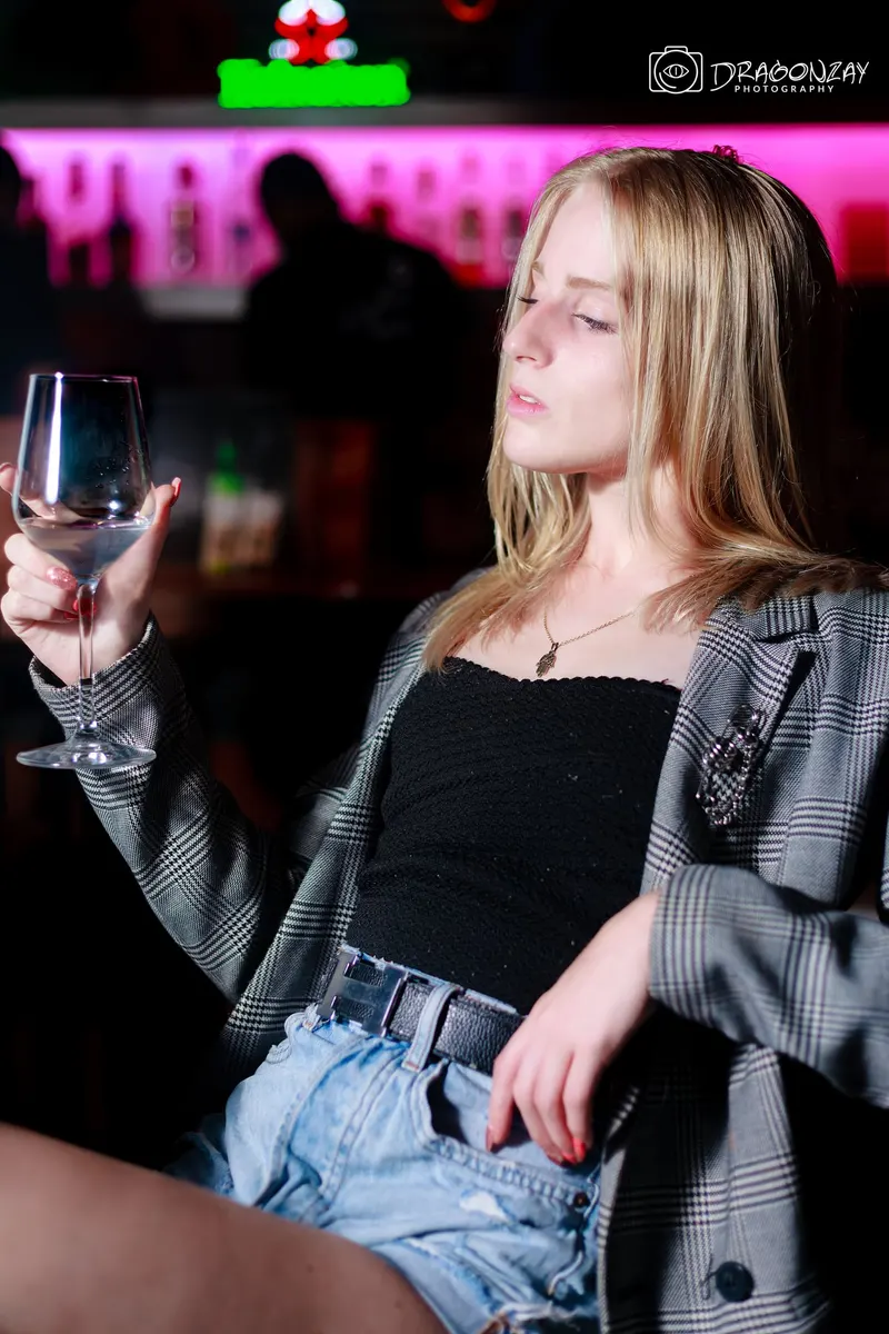 Portrait of a young blonde woman in a grey jacket at the bar - Dragonzay Photography
