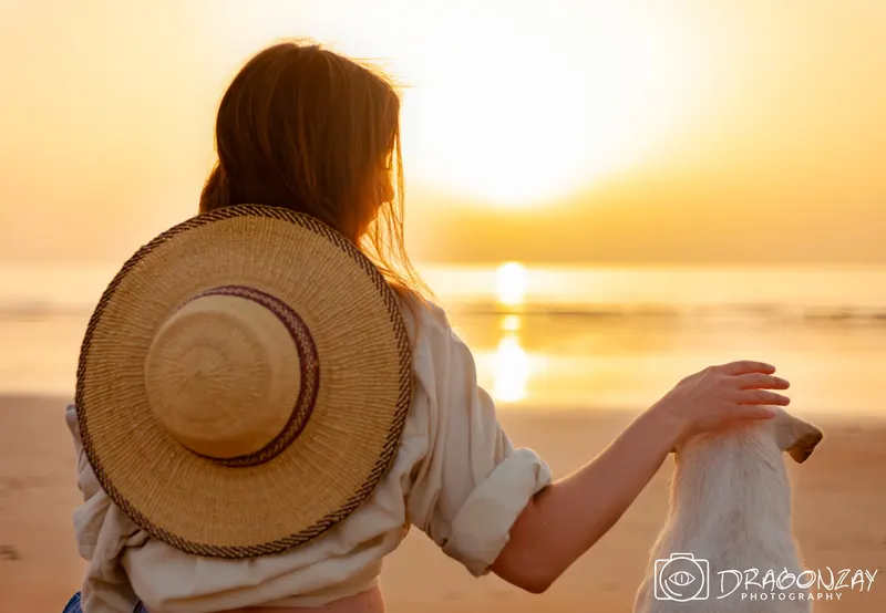 Woman in a straw hat and blue top facing the setting sun - Dragonzay Photography