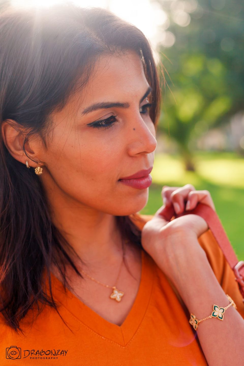 Beauty portrait of a woman in an orange top in a garden - Dragonzay Photography