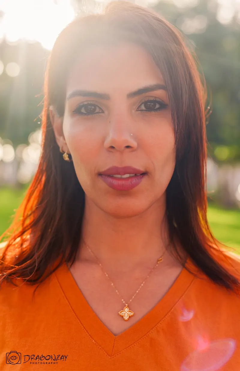 Beauty portrait of a woman in an orange top in a garden - Dragonzay Photography