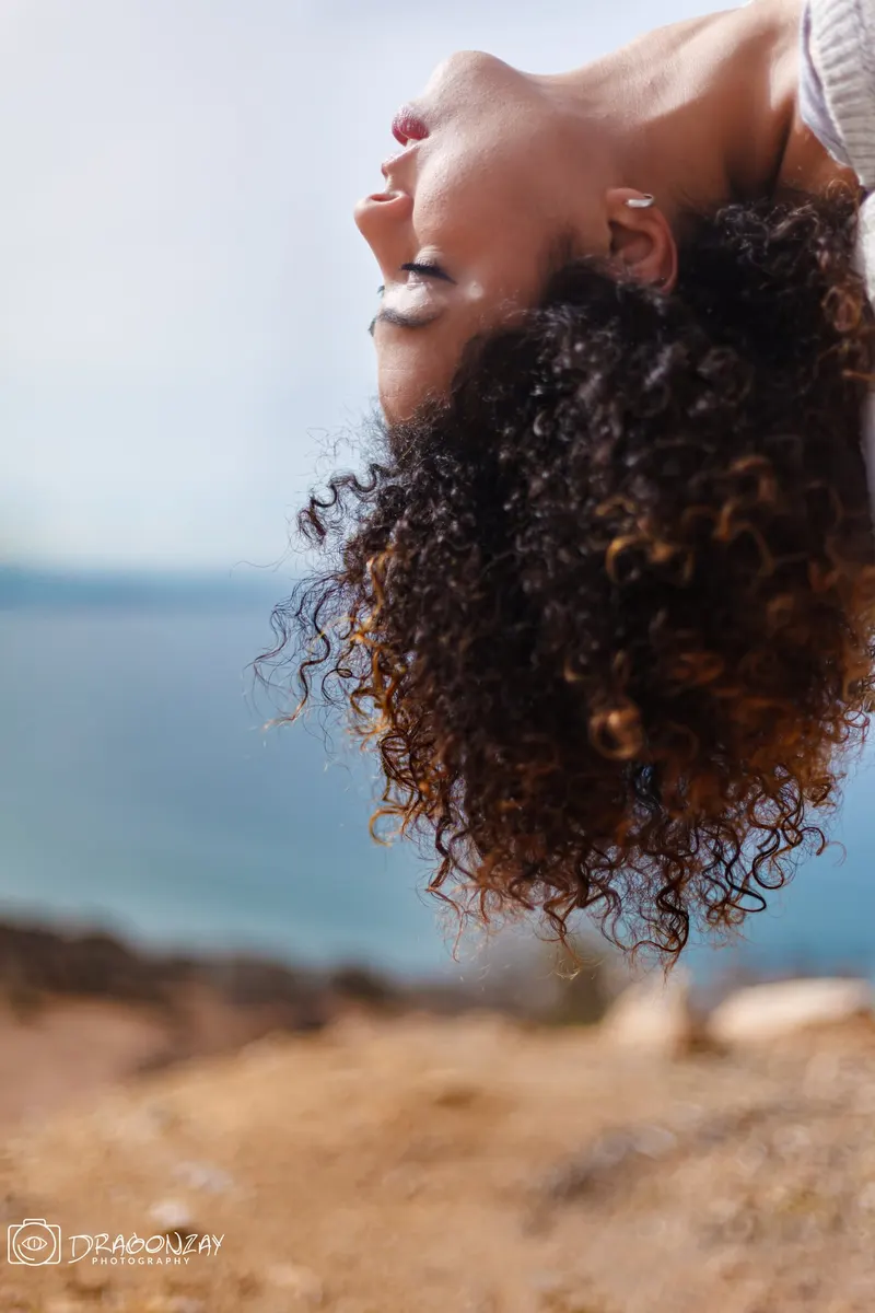 Close-up of curly hair facing the sea - Dragonzay Photography