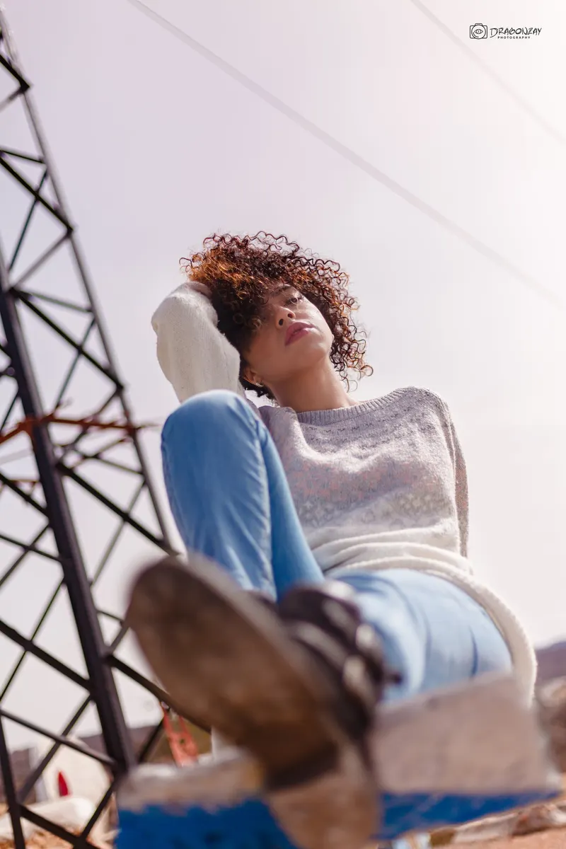 Portrait of a young curly-haired woman in a white sweater - Dragonzay Photography