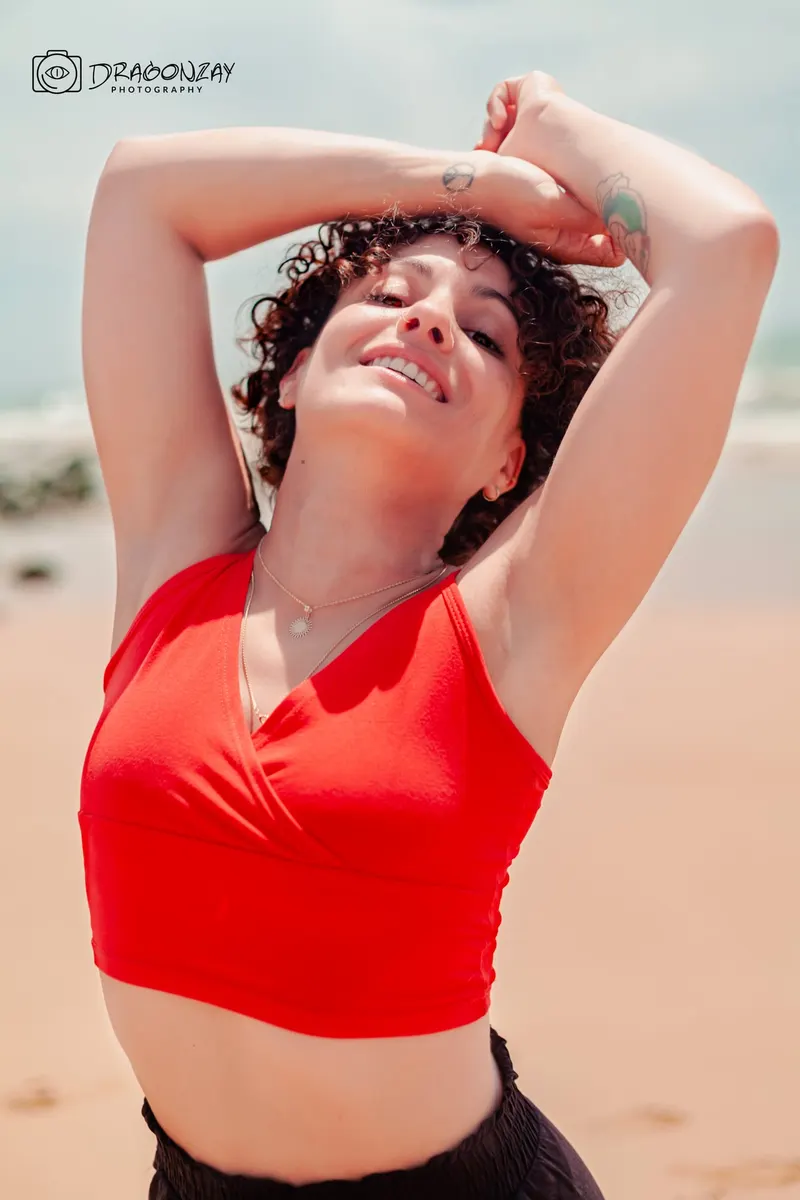 Portrait in a red top, arms raised in the sun - Dragonzay Photography