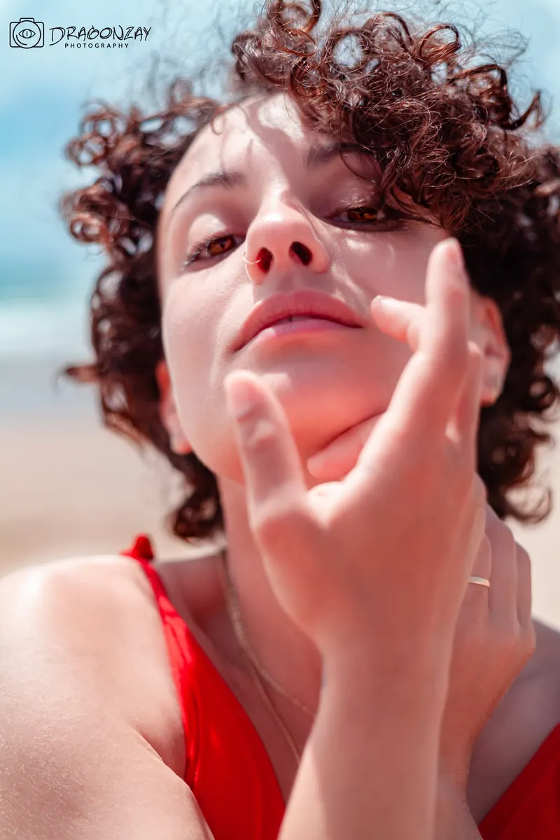 Close-up portrait of a curly-haired young woman in red - Dragonzay Photography