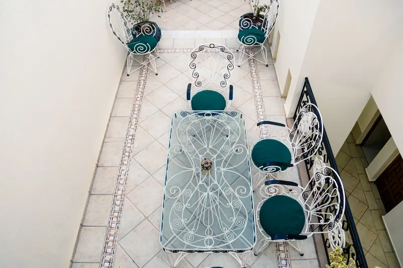 Terrace with white wrought iron furniture and turquoise cushions - Dragonzay Photography