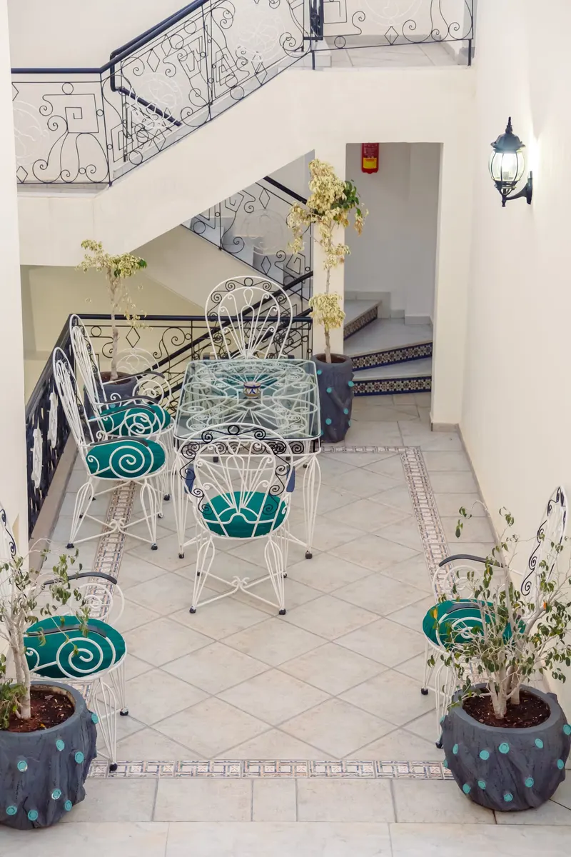 Terrace with white wrought iron furniture and turquoise cushions - Dragonzay Photography