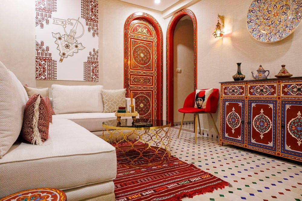 Salon marocain avec banquettes blanches, tapis rouge et portes peintes - Dragonzay Photography