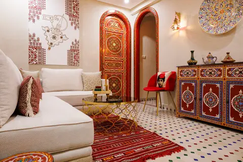 Moroccan lounge with white sofas, a red rug and painted doors - Dragonzay Photography