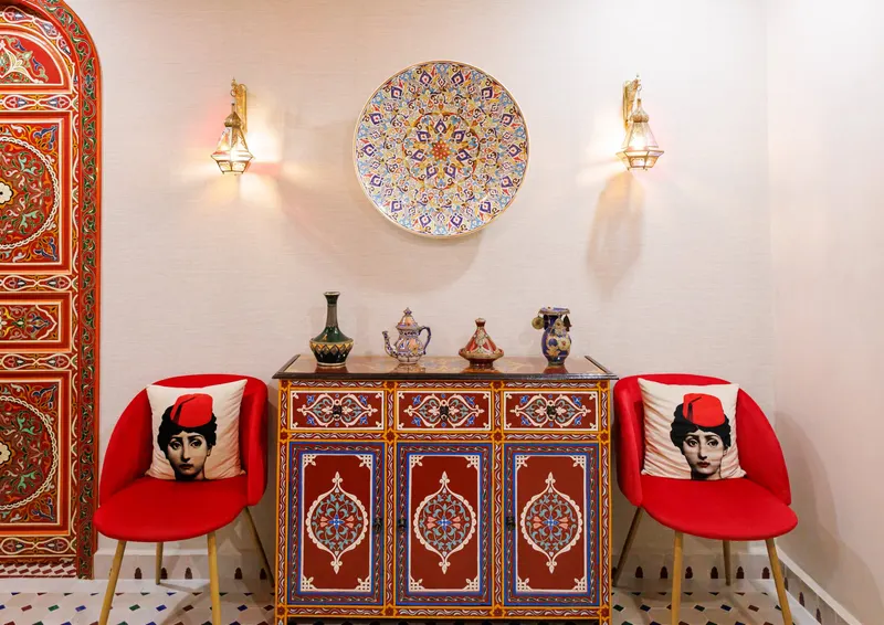 Moroccan lounge with white sofas, a red rug and painted doors - Dragonzay Photography