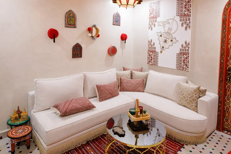 Moroccan lounge with white sofas, a red rug and painted doors - Dragonzay Photography