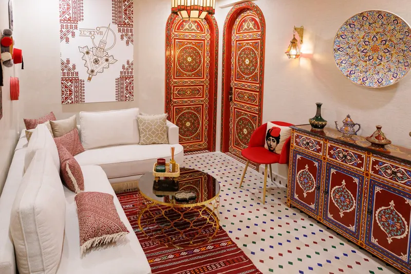 Moroccan lounge with white sofas, a red rug and painted doors - Dragonzay Photography