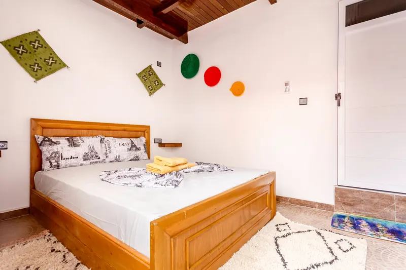 Bedroom with a wooden bed and hat-decorated walls - Dragonzay Photography