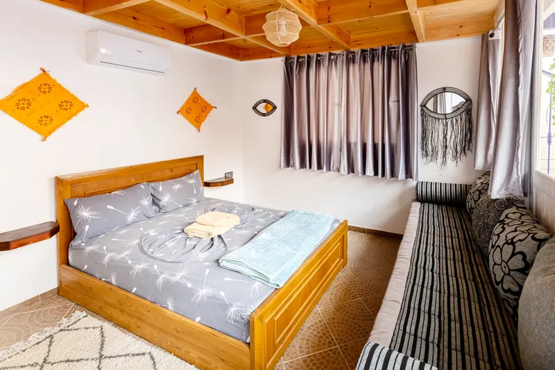 Bedroom with a wooden bed and hat-decorated walls - Dragonzay Photography