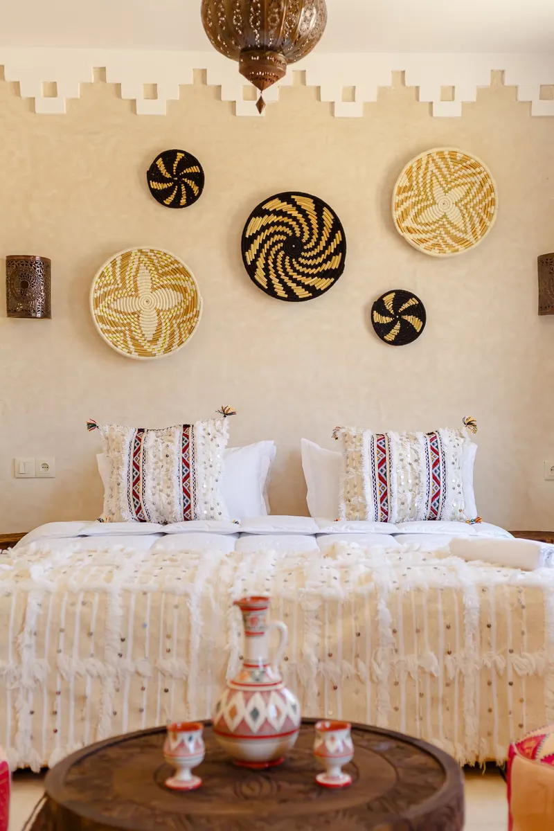 Guest room with woven baskets on the wall and a Berber rug - Dragonzay Photography