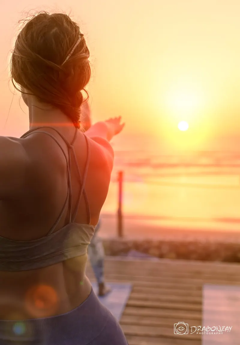 Pratiquante de yoga de dos face au soleil couchant - Dragonzay Photography